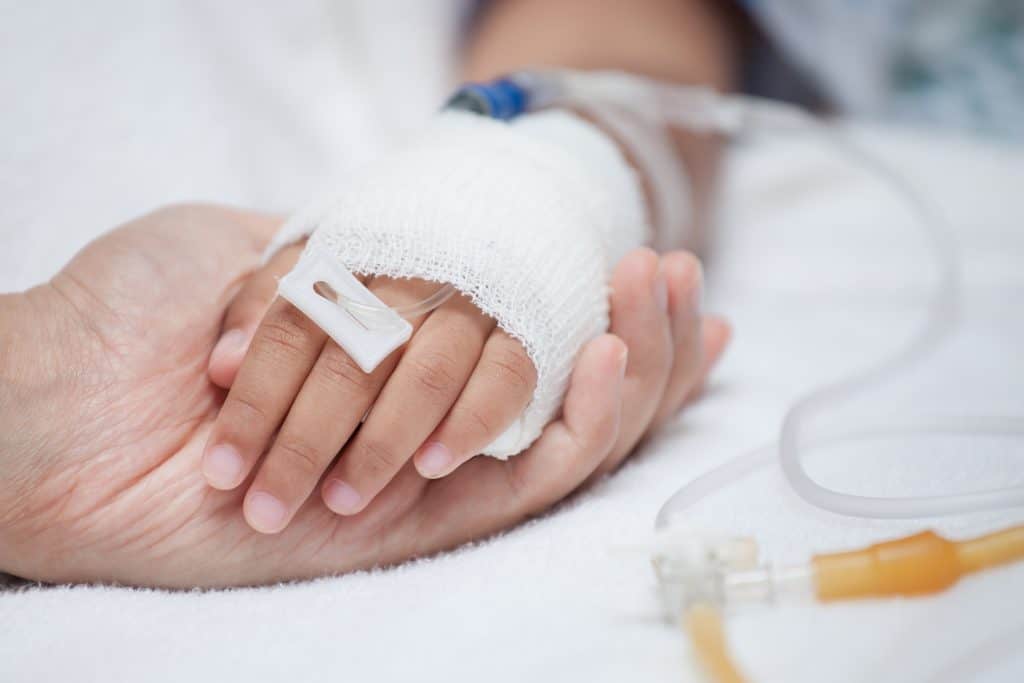Mother hand holding child hand who have IV